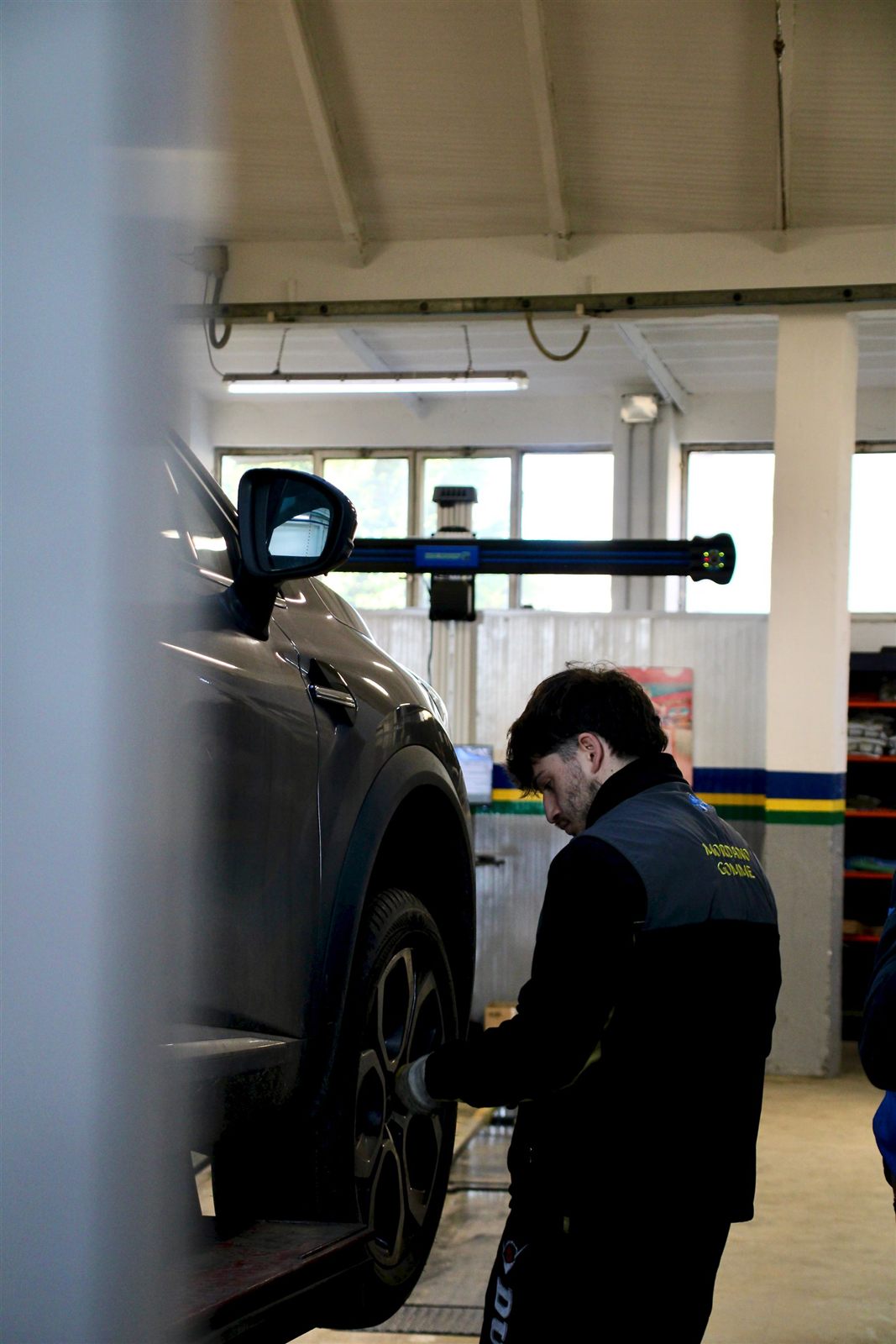 Technician inspecting a vehicle wheel in a professional workshop