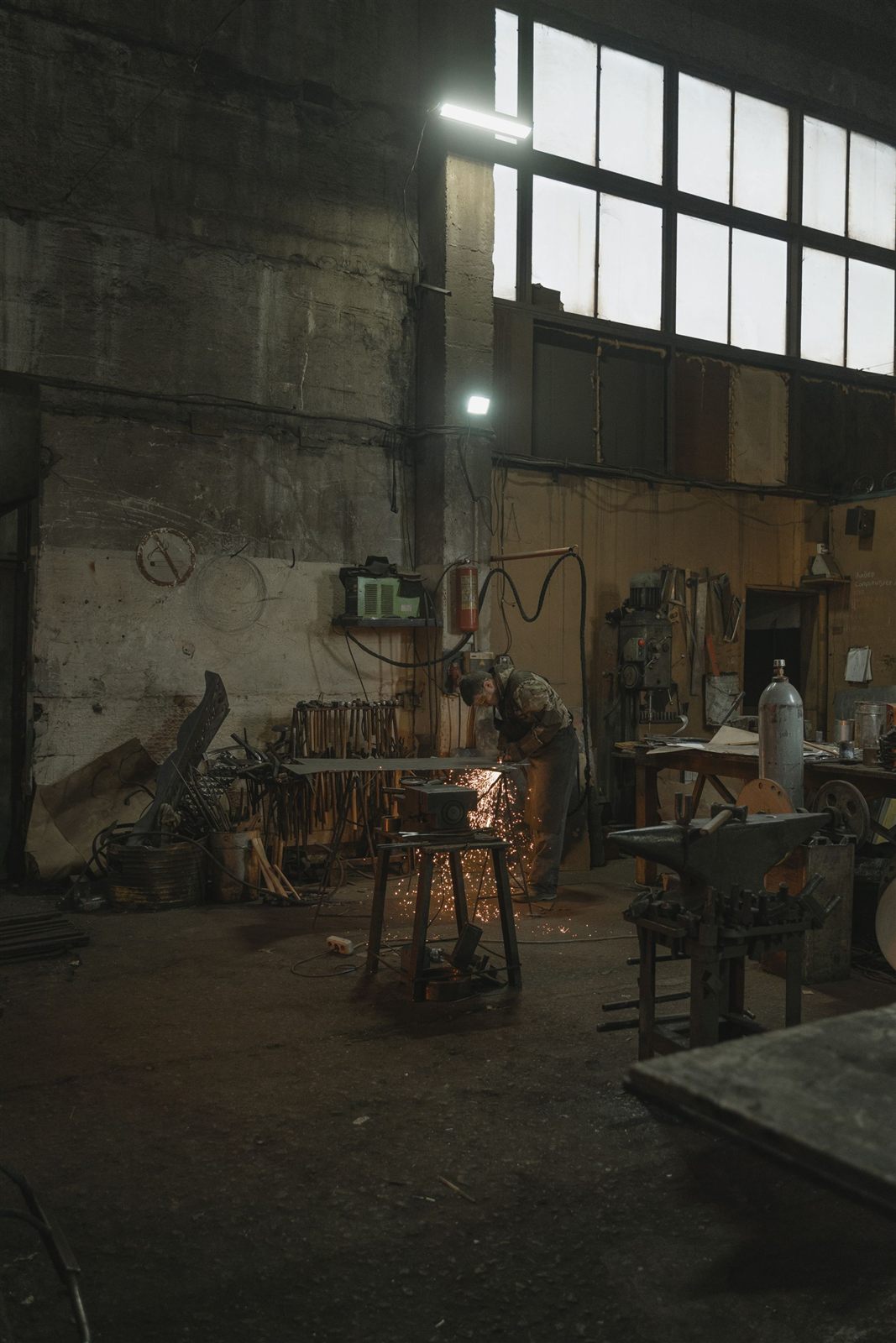 Professional welder carrying out precision metal repair in a workshop
